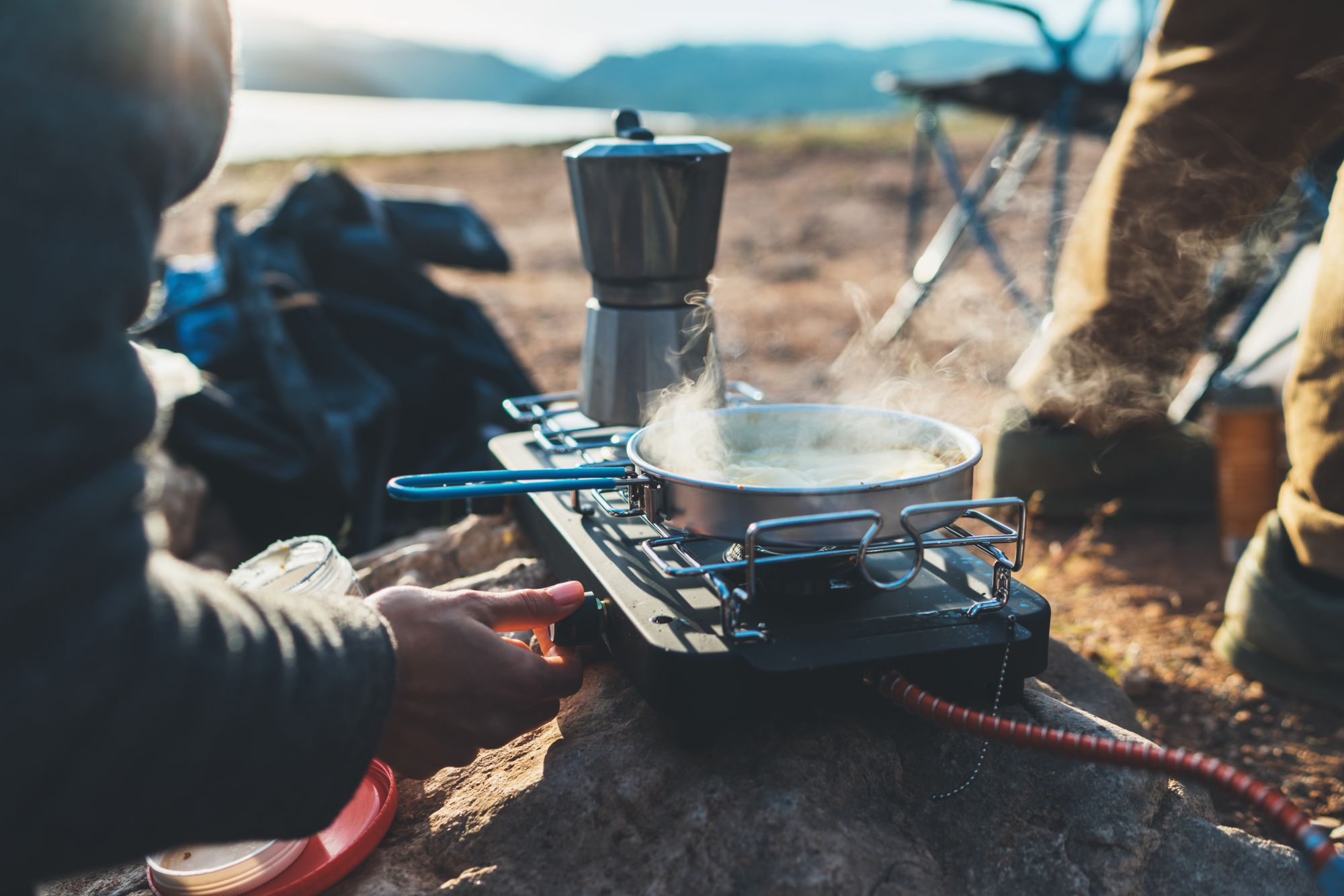 a portable stove with a pan and coffee maker