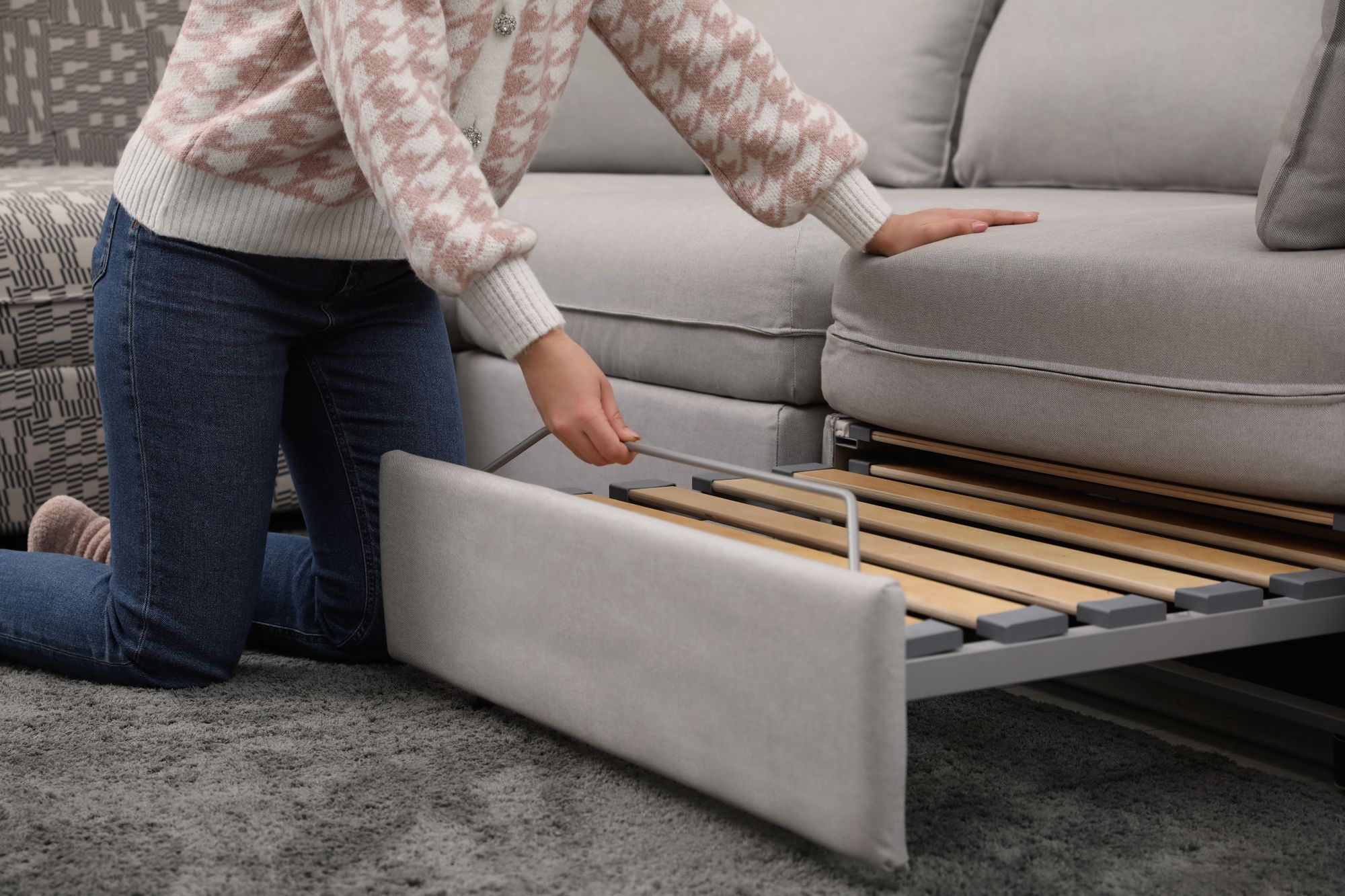 woman opening a sofa bed woman opening a sofa bed